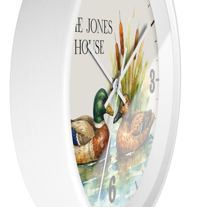 A white round wall clock featuring a watercolor-style duck illustration and the words 'THE JONES HOUSE' on the dial, shown against a plain white background.