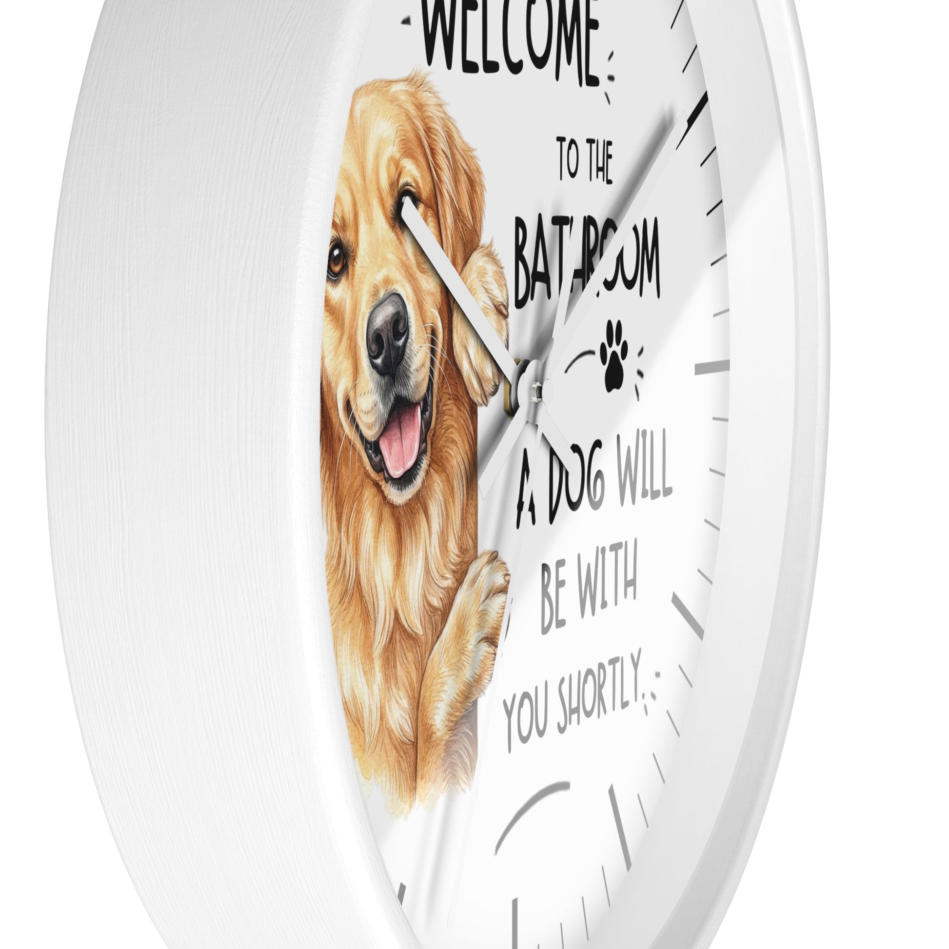 A white round wall clock with a printed face featuring a golden retriever illustration and the text 'WELCOME TO THE BATROOM A DOG WILL BE WITH YOU SHORTLY'.
