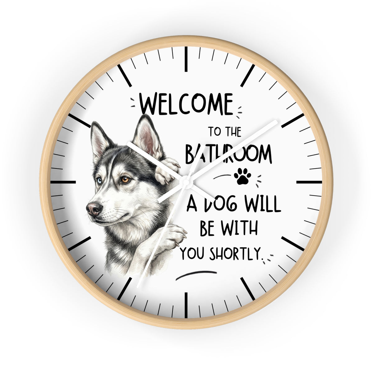 A round wall clock with a light wood frame and a white face, featuring a detailed illustration of a husky dog and the humorous text 'WELCOME TO THE BATHROOM A DOG WILL BE WITH YOU SHORTLY'.