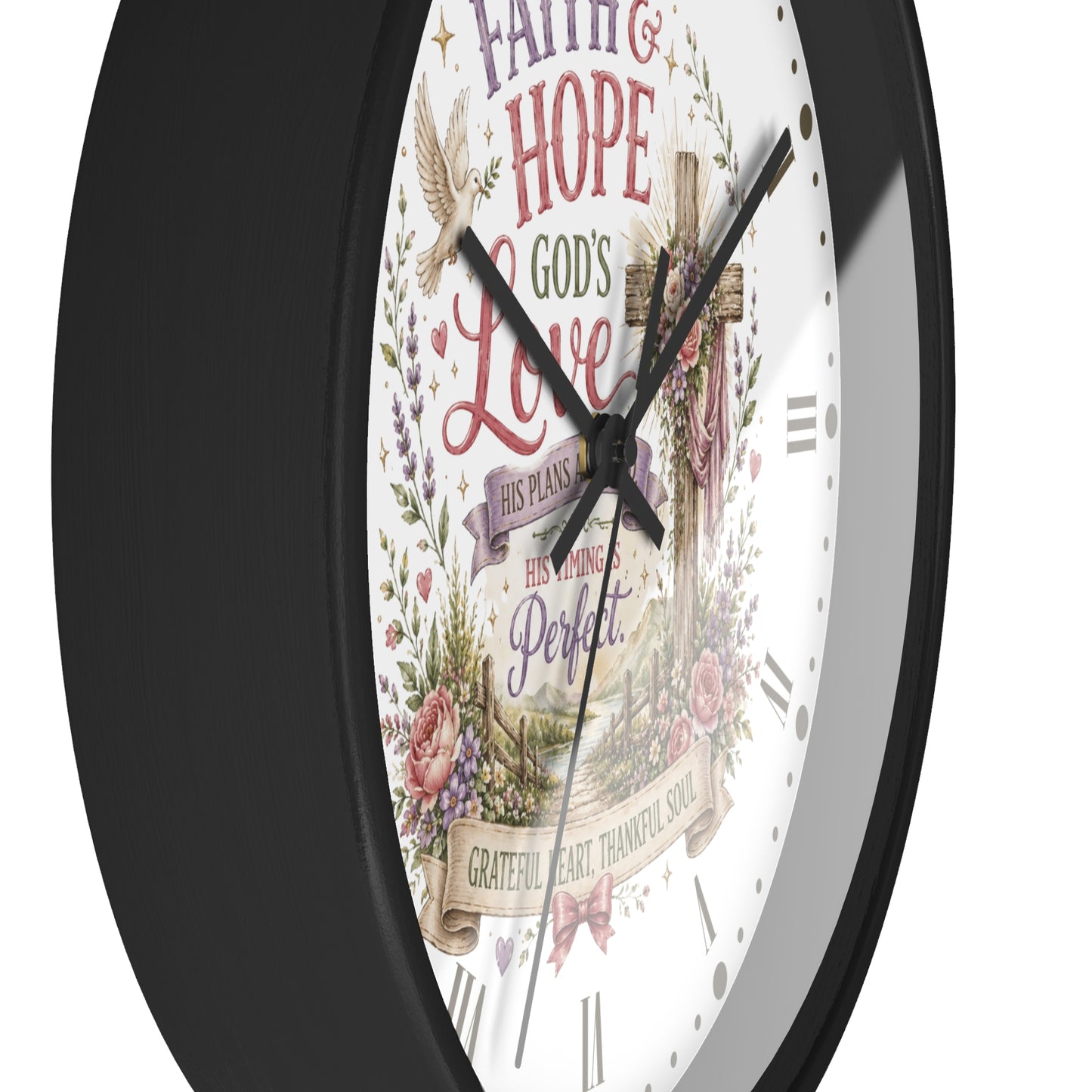 A close-up of a wall clock with a black frame and a white face featuring a Christian inspirational design with a cross, doves, floral elements, and religious text.