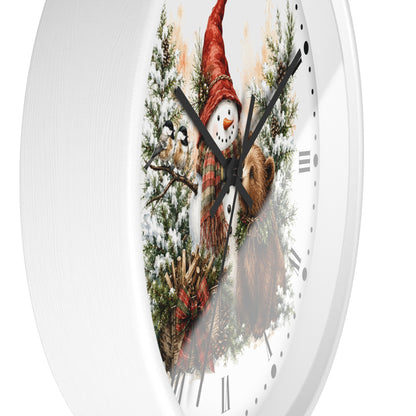 A white round wall clock with a festive winter illustration on the face, featuring a snowman in a red hat, a bird, pine branches, and a brown bear, with black Roman numerals and black hands.