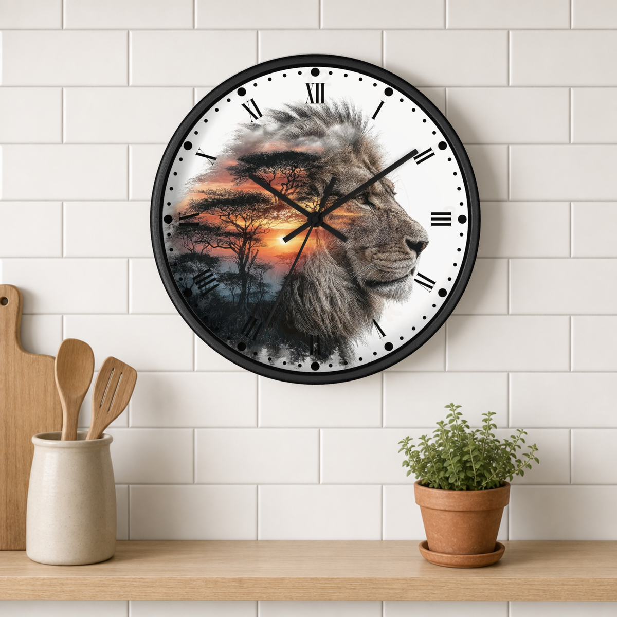 A round wall clock with a black frame hangs on a white subway-tile wall above a wooden shelf. The clock face features a detailed lion profile in grayscale over a sunset landscape with trees and warm orange sky.