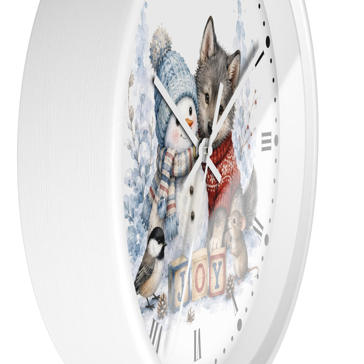 A round white wall clock with a winter-themed illustration on the face, showing a snowman, a wolf, a bird, and the word "JOY" in colorful blocks. The clock is photographed against a clean white background.