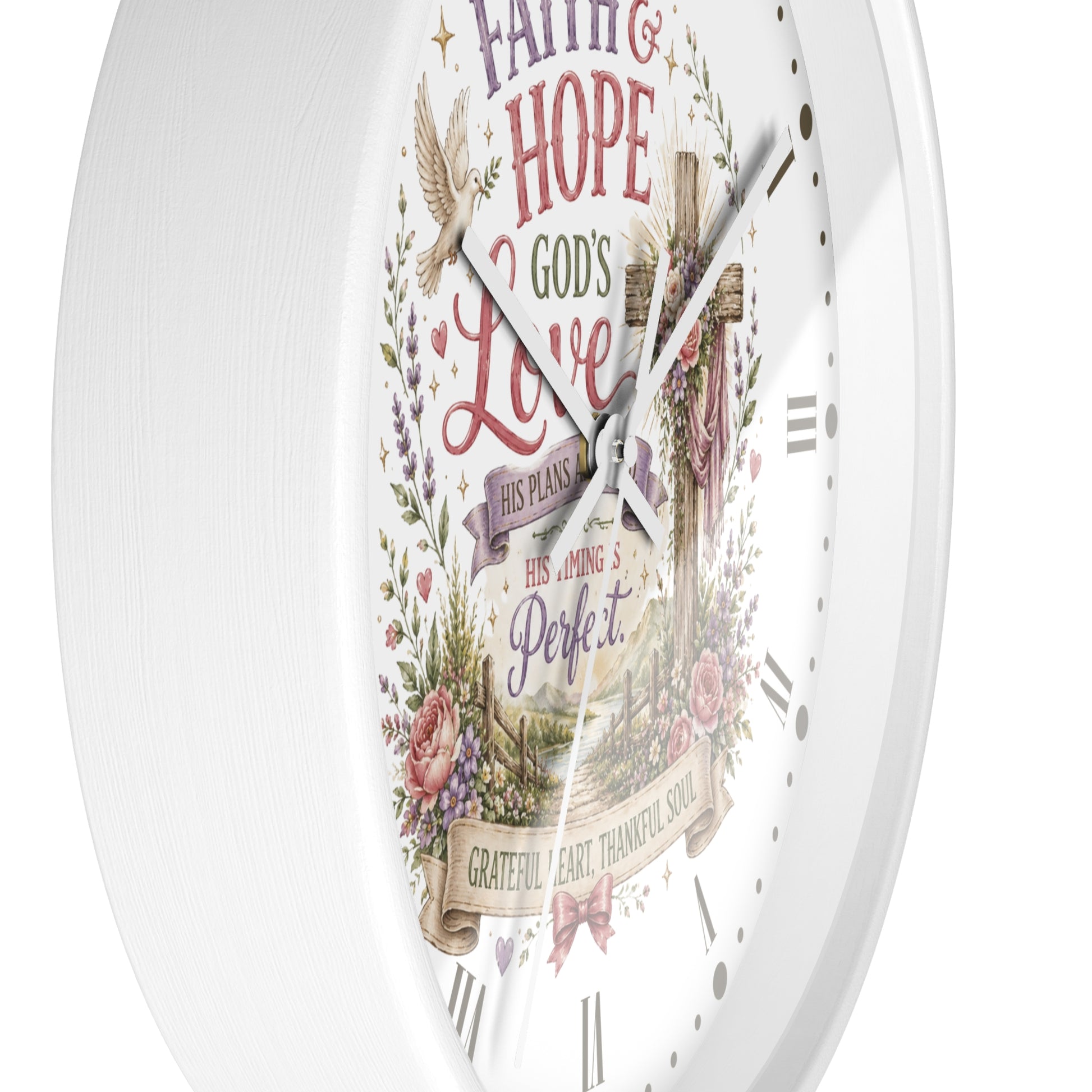 A white round wall clock with a vintage-style religious design on the face, featuring the words 'Faith, Hope, Love', a cross, floral elements, and Roman numeral hour markers.