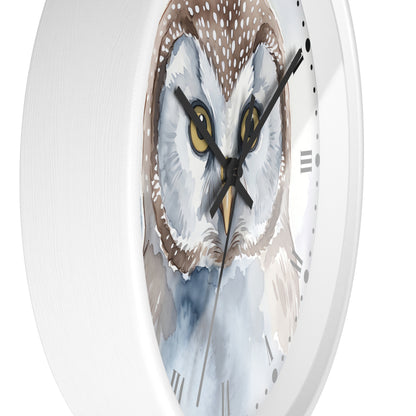 A close-up of a round wall clock with a white frame and a watercolor-style owl face printed on the dial. The clock has black hands, black hour markers, and a white background.