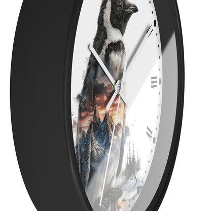 A round wall clock with a black frame and a white face featuring a printed penguin and mountain landscape design, shown against a plain white background.