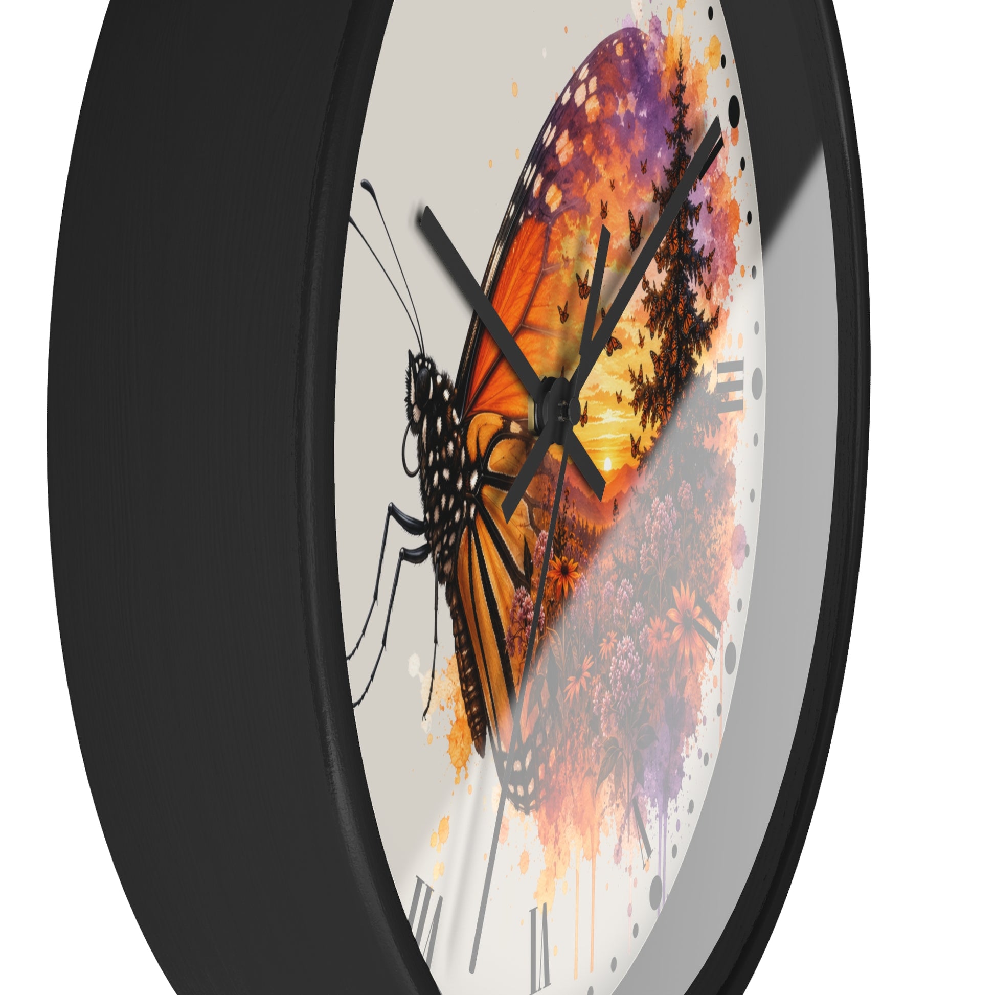 A close-up of a round wall clock with a black frame and a white dial featuring a stylized butterfly and floral artwork in orange, purple, and yellow tones.