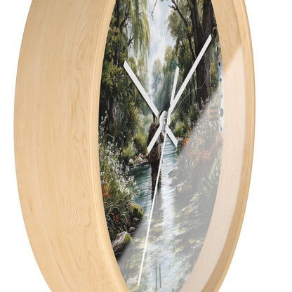 Round wall clock with a light natural wood frame and a printed scenic forest stream artwork on the face, with white hands on a white background.