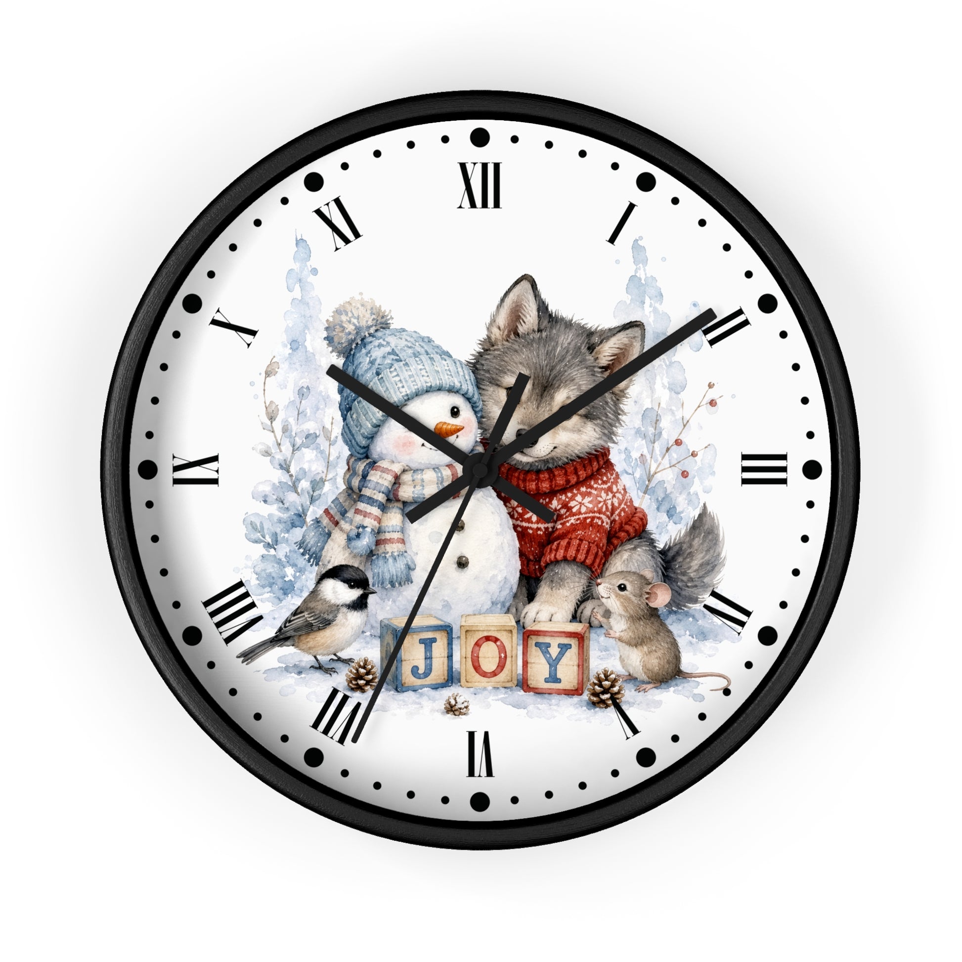 A round wall clock with a black frame and a white face featuring a winter illustration of a wolf, snowman, bird, and mouse around the word 'JOY' in wooden blocks, with Roman numerals as hour markers.