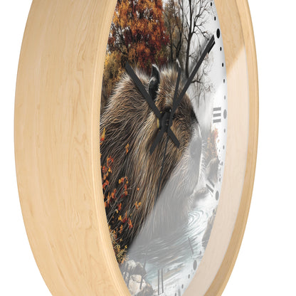 Round wall clock with a light natural wood frame and a printed face showing a capybara in an autumn forest scene, photographed on a white background.