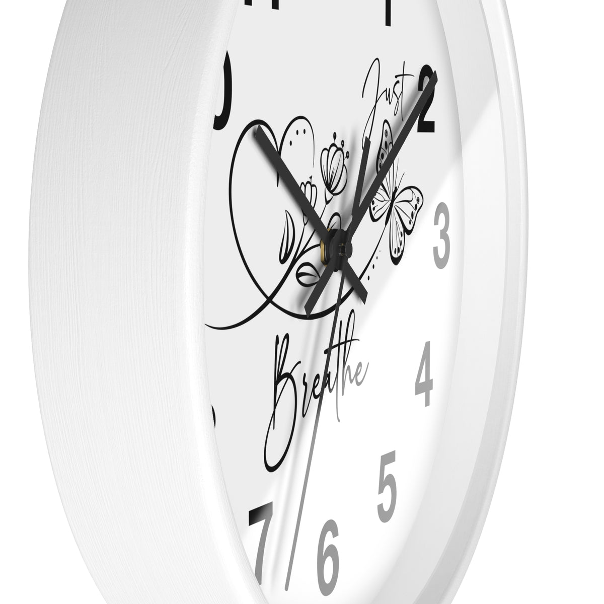 A close-up of a white round wall clock with black hands, black numerals, and black decorative script and butterfly artwork on the face.