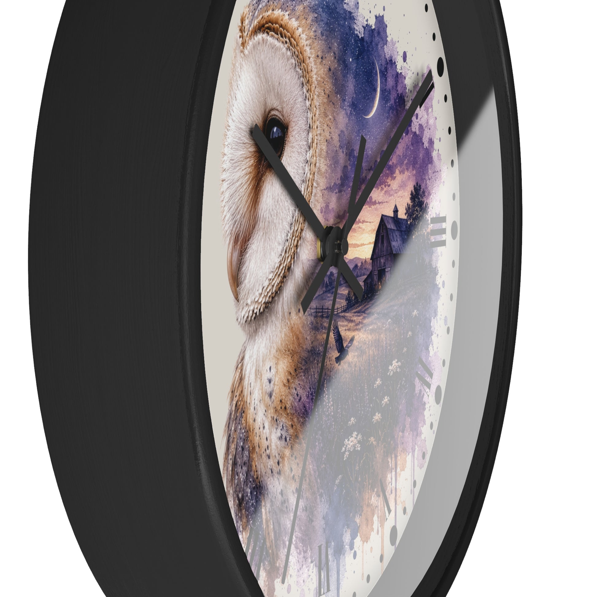 A round wall clock with a black frame and a printed owl artwork on the face. The design shows a large white and brown owl over a purple and blue watercolor landscape with a house and moon.