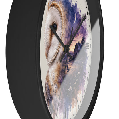 A round wall clock with a black frame and a printed owl artwork on the face. The design shows a large white and brown owl over a purple and blue watercolor landscape with a house and moon.