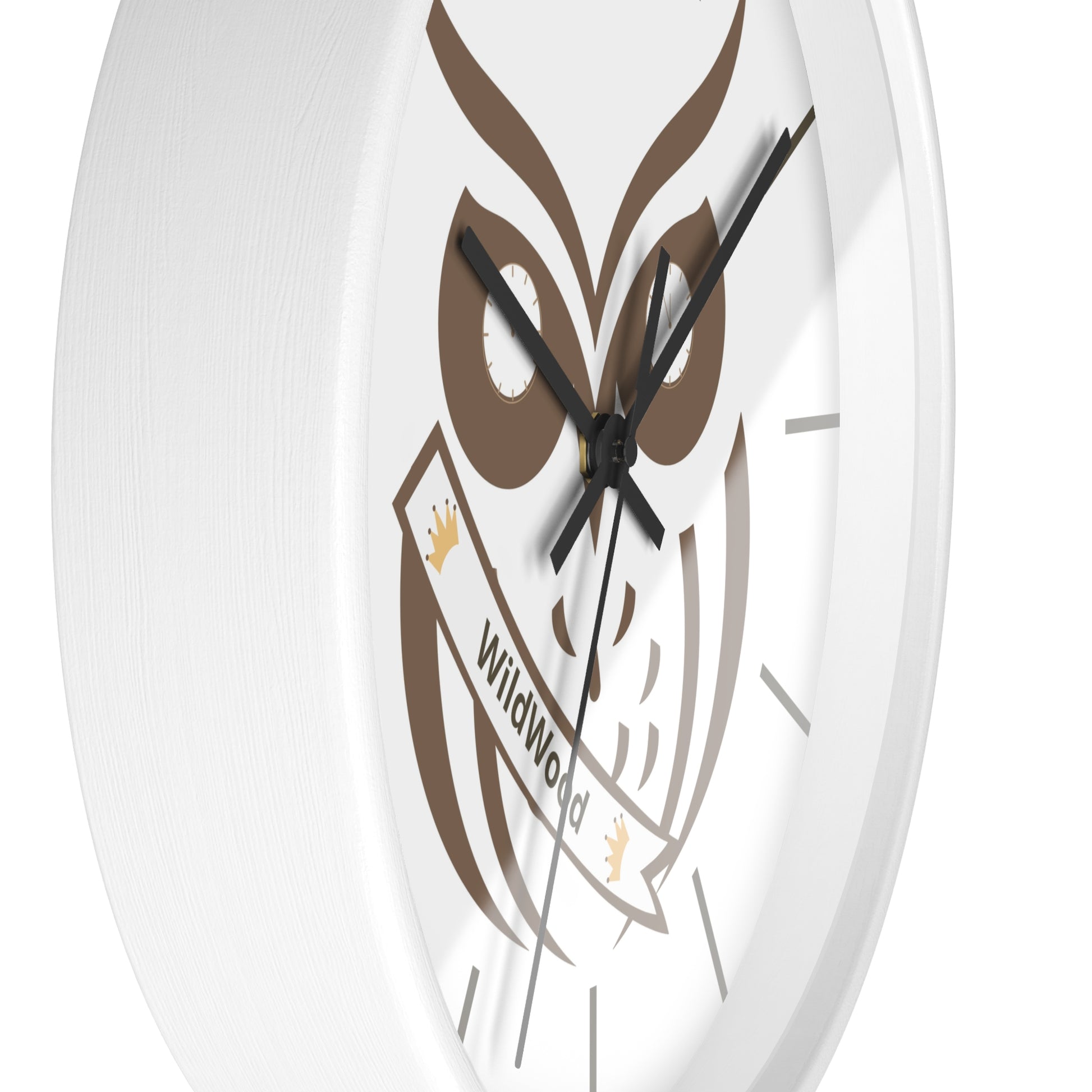 A close-up of a round white wall clock featuring a brown owl graphic and a banner that reads 'Wildwood'.