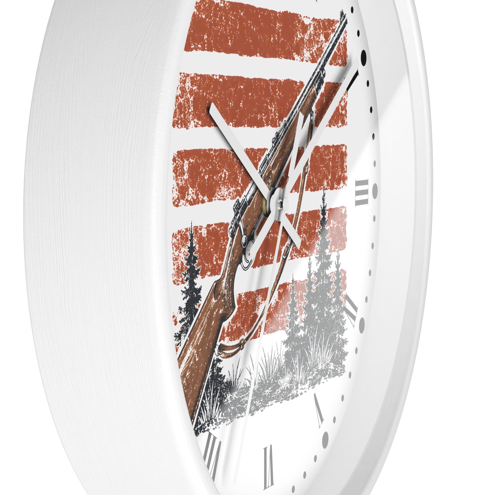 A white round wall clock with a rustic design, featuring a brown rifle, pine trees, and distressed orange and white horizontal stripes on the face.