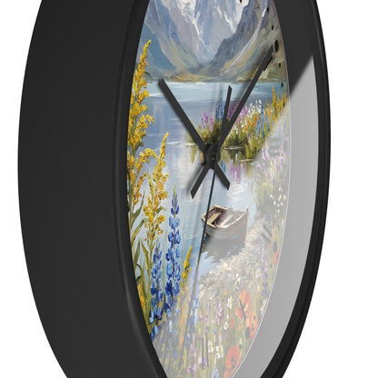 Round wall clock with a black frame and a scenic landscape print featuring a lake, mountains, wildflowers, and a rowboat, shown against a white background.