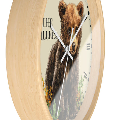 Round wall clock with a light natural wood frame and a printed face showing a brown bear illustration, Roman numerals, and black hands on a white background.