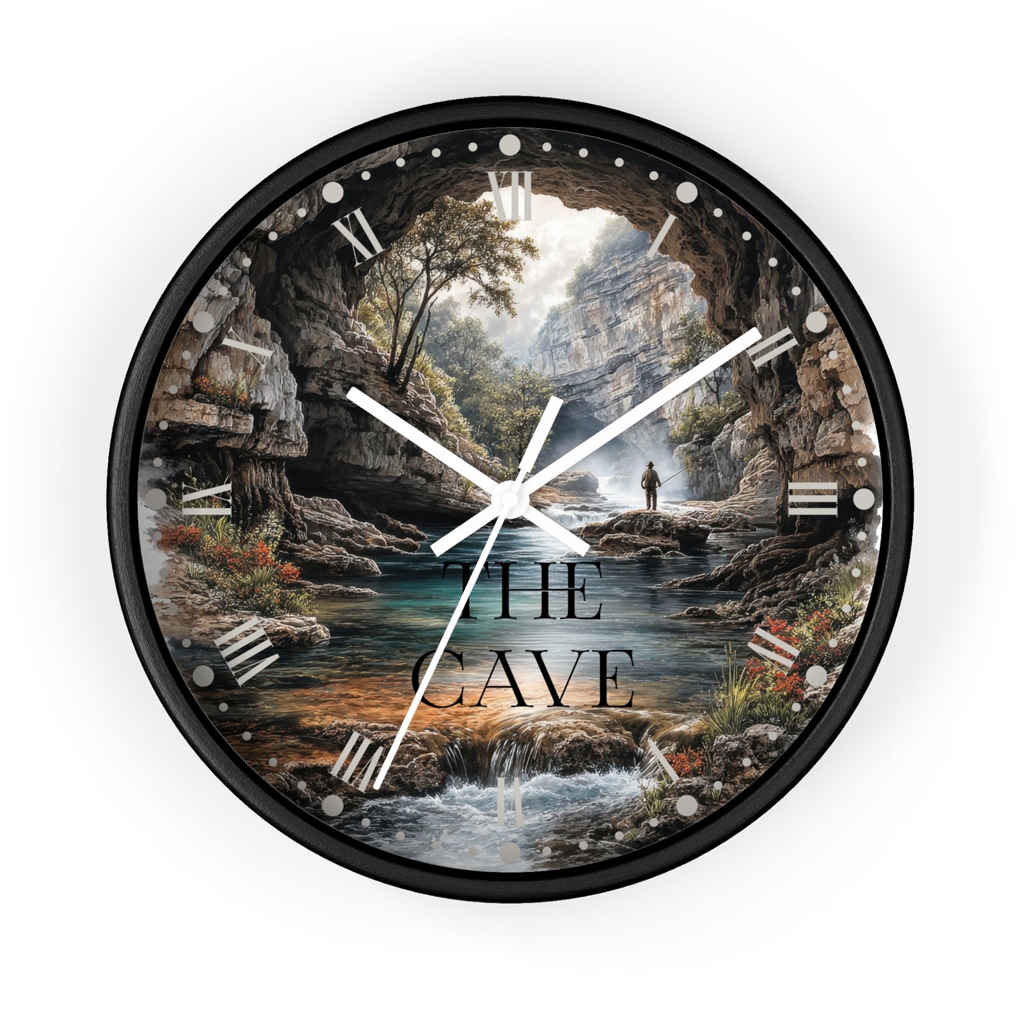 A round wall clock with a black frame and a scenic landscape print featuring a cave opening over a stream, trees, rocks, and the text 'THE CAVE'. White clock hands and Roman numeral hour markers are visible against a plain white background.