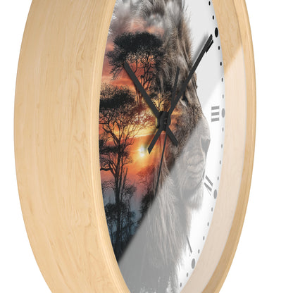 Round wall clock with a light natural wood frame and a printed face featuring a lion silhouette over an African savanna sunset scene, shown on a white background.