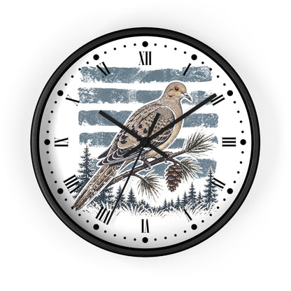 A round wall clock with a black frame and a white face featuring a detailed illustration of a brown dove bird perched on a pine branch, with blue-gray brushstroke stripes and a forest scene behind it.