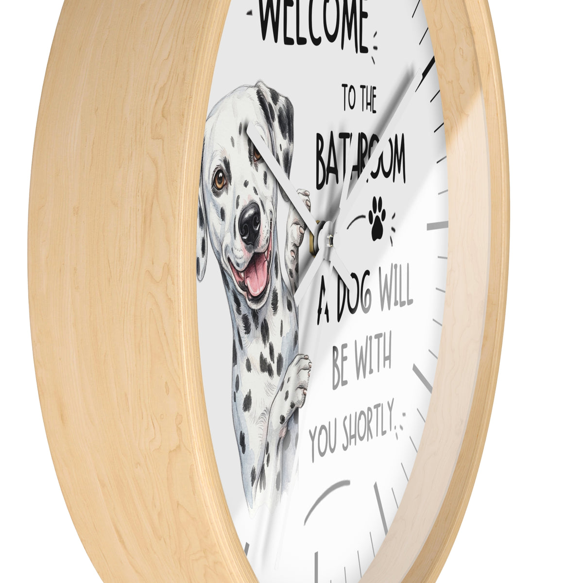 Round wall clock with a light natural wood frame and a white face featuring a Dalmatian illustration and the text 'WELCOME TO THE BATROOM A DOG WILL BE WITH YOU SHORTLY'.