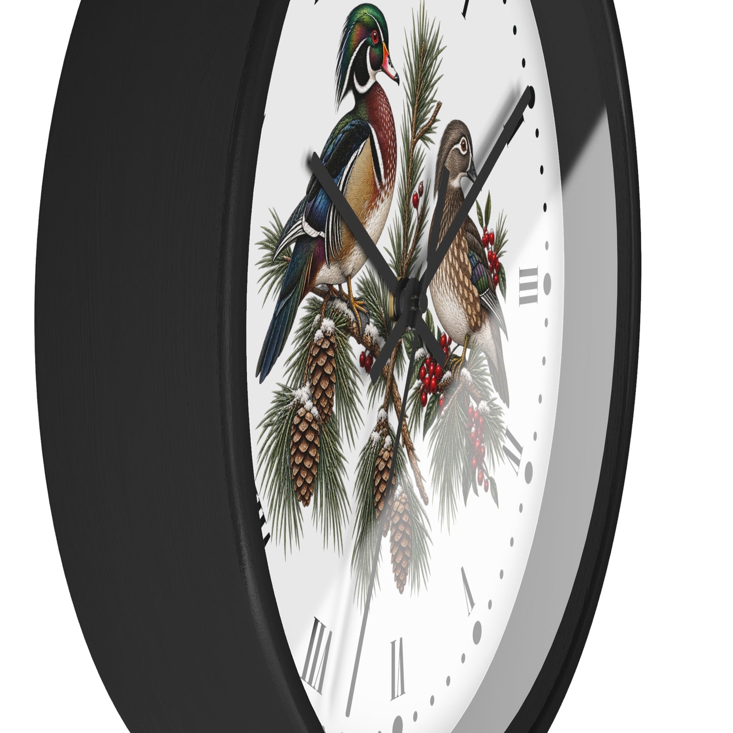 A close-up of a wall clock with a black frame and a white face featuring an illustration of two wood ducks perched on pine branches with pinecones and red berries.