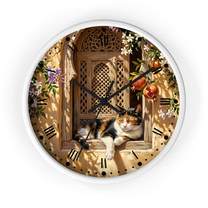 Round wall clock with a white rim and a printed design of a calico cat resting on a wooden window ledge, surrounded by flowers, pomegranates, and a warm beige background with black Roman numerals.