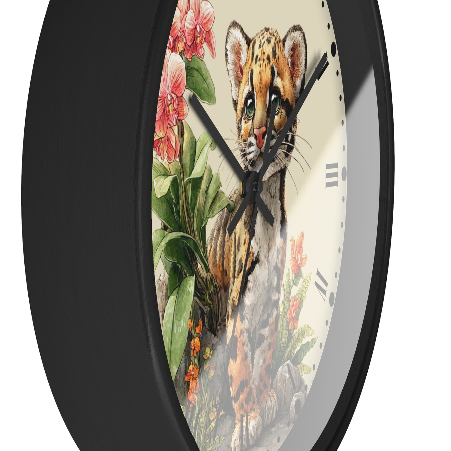 A close-up of a round wall clock with a black frame and a detailed illustration of a spotted cat kitten surrounded by pink flowers and green leaves on the face.