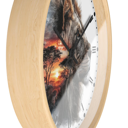 Round wall clock with a light natural wood frame and a printed design on the face showing a lion's face over an orange sunset savanna scene, photographed on a white background.