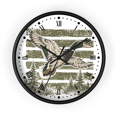 Round wall clock with a black frame and a printed dial featuring a flying mallard duck over olive-green striped trees, with Roman numerals and black hour markers.