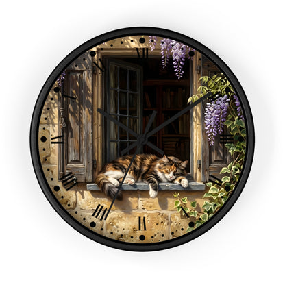 Round wall clock with a black frame and a printed illustration of a fluffy orange-and-white cat resting on a stone windowsill, with wooden shutters, a dark window interior, purple wisteria flowers, and green ivy. Roman numerals are printed around the edge.