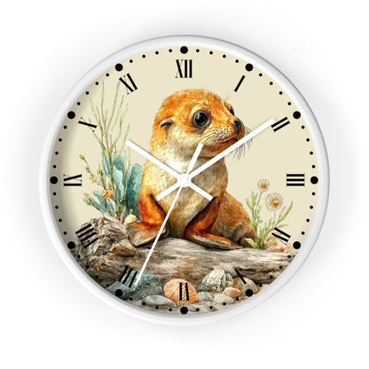 Round wall clock with a white frame and a cream-colored face featuring an illustration of a brown seal pup sitting on driftwood with plants and shells. The clock has black Roman numerals and white hands.