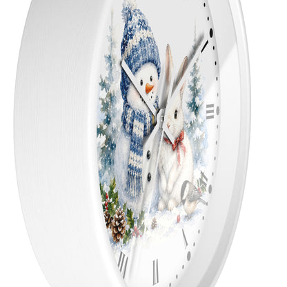 A round white wall clock with a winter illustration on the face, showing a snowman in a blue hat and scarf next to a white rabbit in a snowy scene.