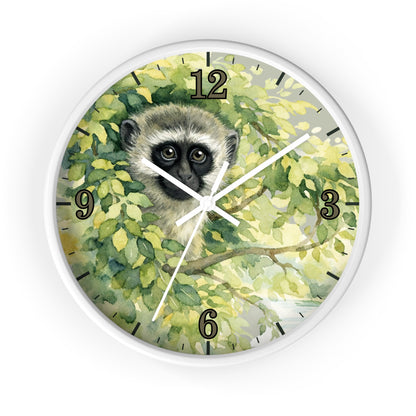 Round wall clock with a white frame and a printed illustration of a vervet monkey among green leaves, with black Arabic numerals and white clock hands on a white background.