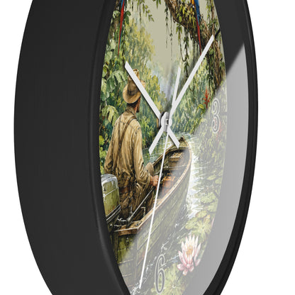 Round wall clock with a black frame and a printed scenic dial showing a man in a boat on a river surrounded by lush green foliage. The clock has white hands and a thin second hand, photographed against a plain white background.