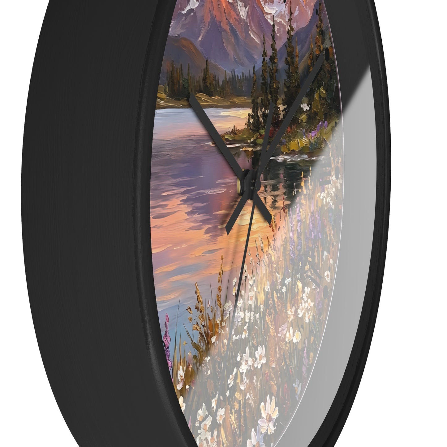 Round wall clock with a black frame and a scenic landscape print featuring a lake, mountains, trees, and wildflowers, shown against a white background.