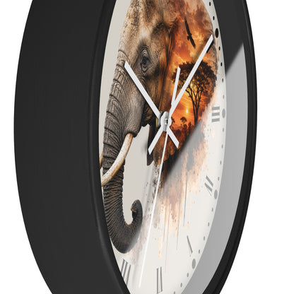 A round wall clock with a black frame and a white face featuring a split design: one half shows a detailed elephant, and the other half shows an African savanna sunset scene. The clock has white hands and Roman numerals.