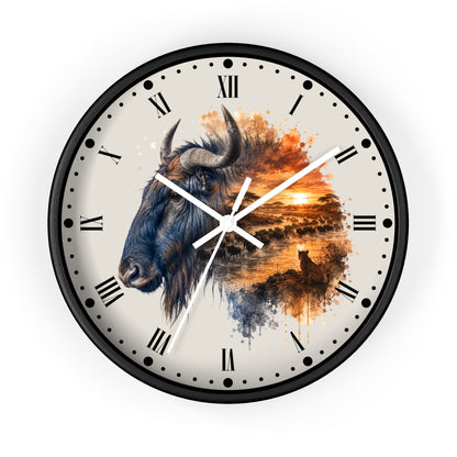 A round wall clock with a black frame and a cream-colored face featuring a watercolor-style illustration of a bison and a sunset landscape. The clock has black Roman numerals and white hands.