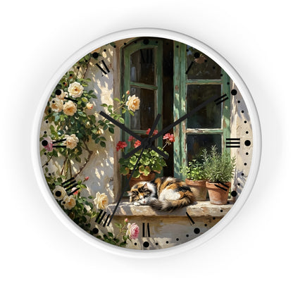 Round wall clock with a white frame and a printed illustration of a cat resting on a windowsill beside climbing roses and potted plants, shown against a plain white background.
