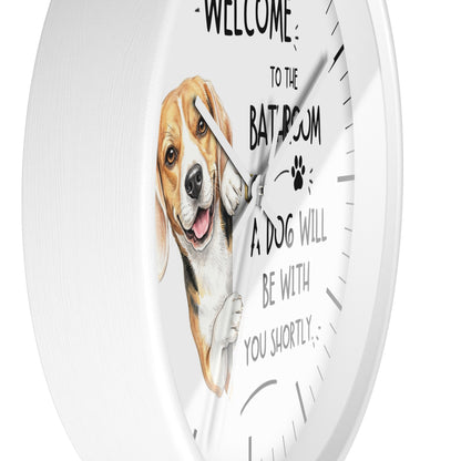 A white round wall clock with a printed illustration of a beagle dog and the text 'WELCOME TO THE BATHROOM A DOG WILL BE WITH YOU SHORTLY' on the front.