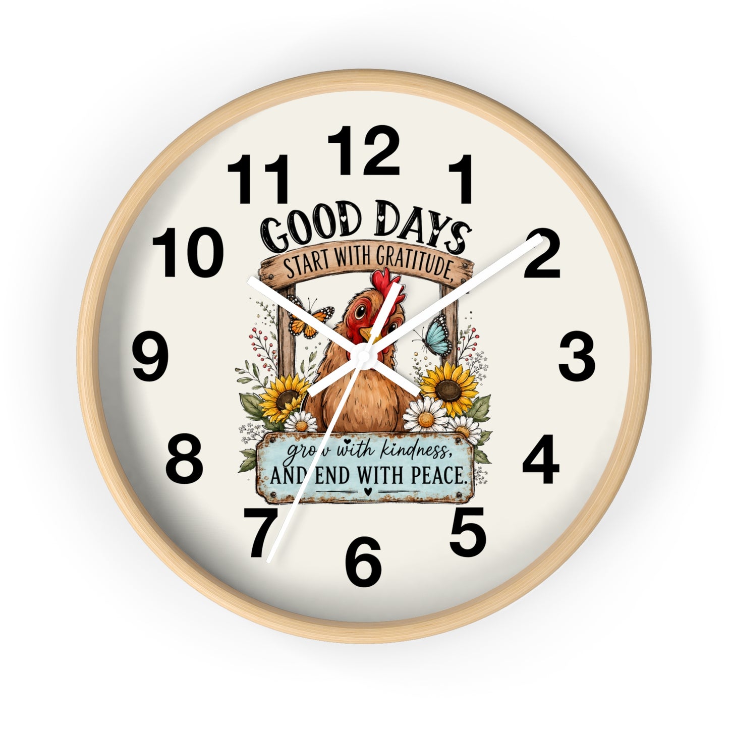 A round wall clock with a light natural wood frame and a cream-colored face. The clock face features a central illustration of a brown chicken surrounded by sunflowers, a butterfly, and a banner that reads 'GOOD DAYS START WITH GRATITUDE' and 'grow with kindness AND END WITH PEACE'.