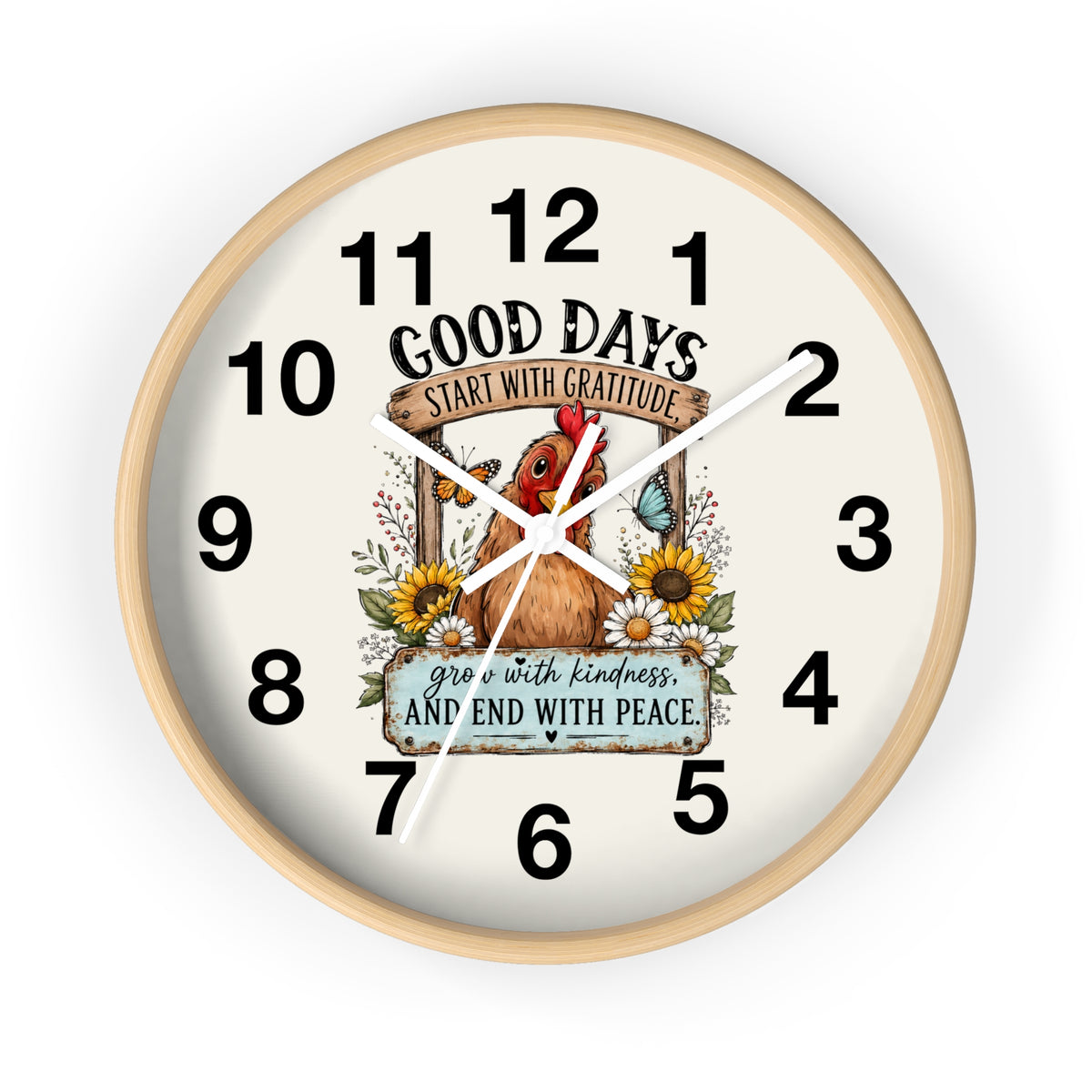 A round wall clock with a light natural wood frame and a cream-colored face. The clock face features a central illustration of a brown chicken surrounded by sunflowers, a butterfly, and a banner that reads 'GOOD DAYS START WITH GRATITUDE' and 'grow with kindness AND END WITH PEACE'.