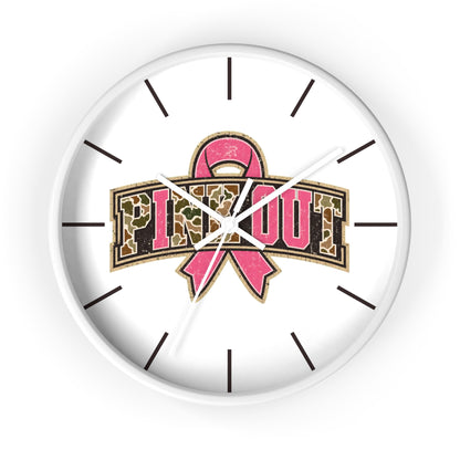 A round white wall clock with a pink breast cancer awareness ribbon and the words 'PINK OUT' in leopard-print lettering, shown against a plain white background.