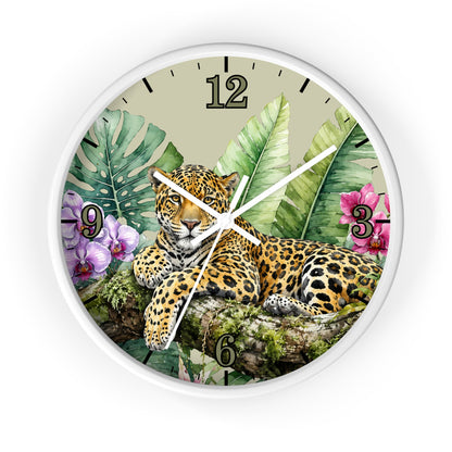 A round wall clock with a white frame and a tropical jungle design featuring a leopard resting among green leaves and pink flowers. The clock face has black Arabic numerals and white hands.