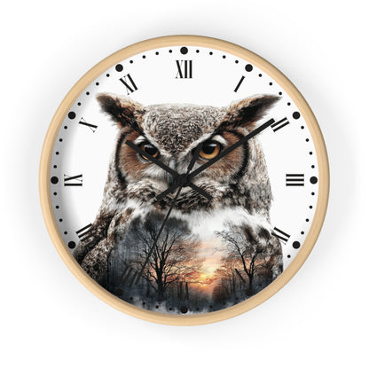 Round wall clock with a light wood frame and a white face featuring a large owl over a forest sunset scene. The clock has black Roman numerals and black hands, shown against a plain white background.
