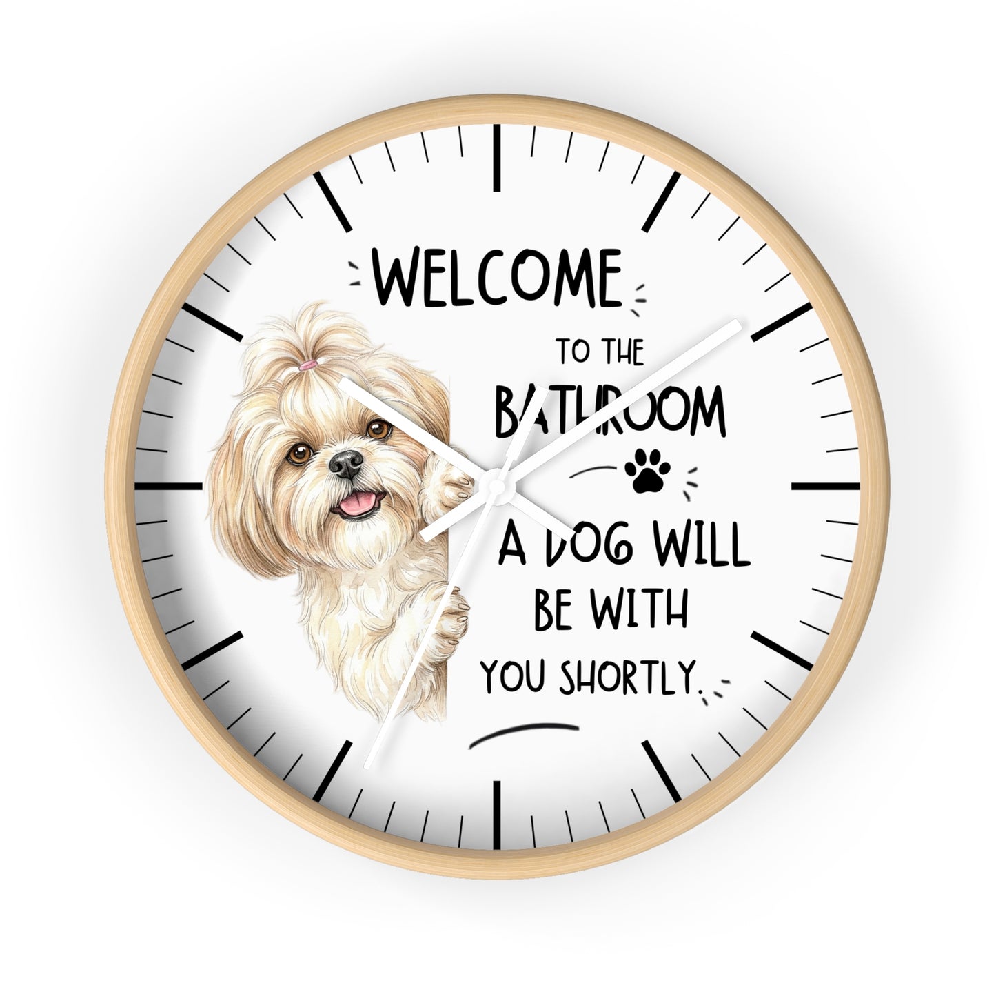A round wall clock with a light wood frame and a white face, featuring a small fluffy dog illustration and the text 'WELCOME TO THE BATHROOM A DOG WILL BE WITH YOU SHORTLY.' on a plain white background.
