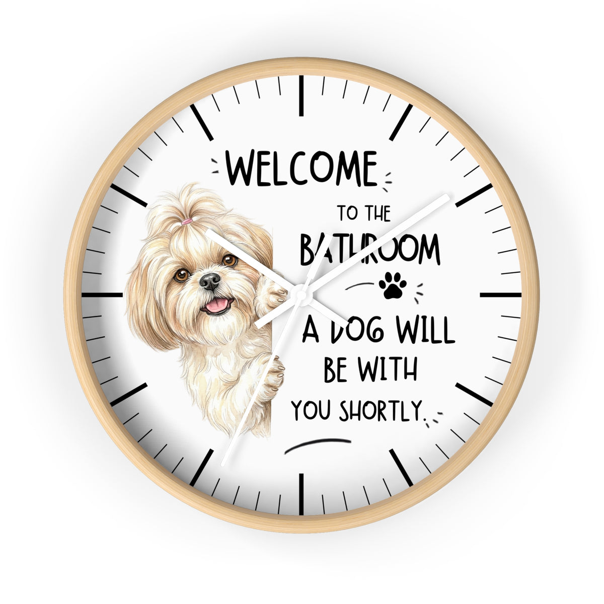 A round wall clock with a light wood frame and a white face, featuring a small fluffy dog illustration and the text 'WELCOME TO THE BATHROOM A DOG WILL BE WITH YOU SHORTLY.' on a plain white background.
