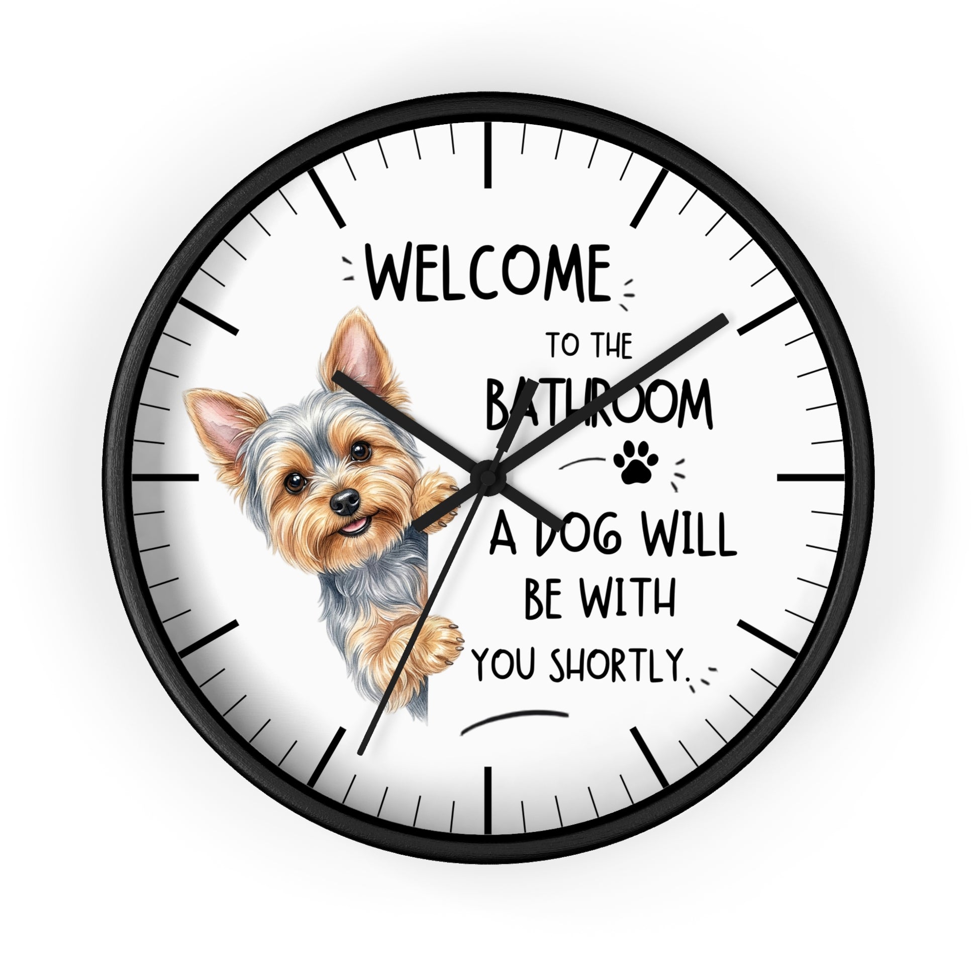 A round wall clock with a black frame and white face, featuring a small dog illustration and the text 'WELCOME TO THE BATHROOM A DOG WILL BE WITH YOU SHORTLY.' on a light gray background.