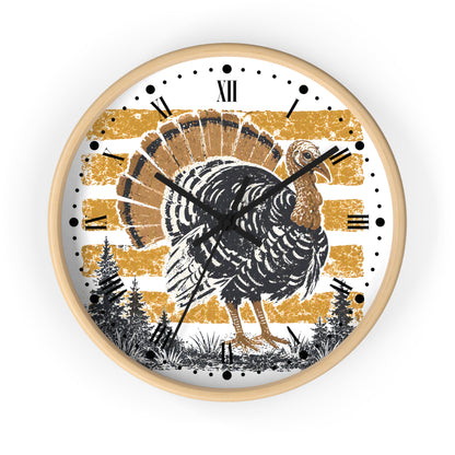 A round wall clock with a light natural wood frame, featuring a distressed graphic of a black and brown turkey on a white face with gold horizontal stripes, Roman numerals, and black hands.