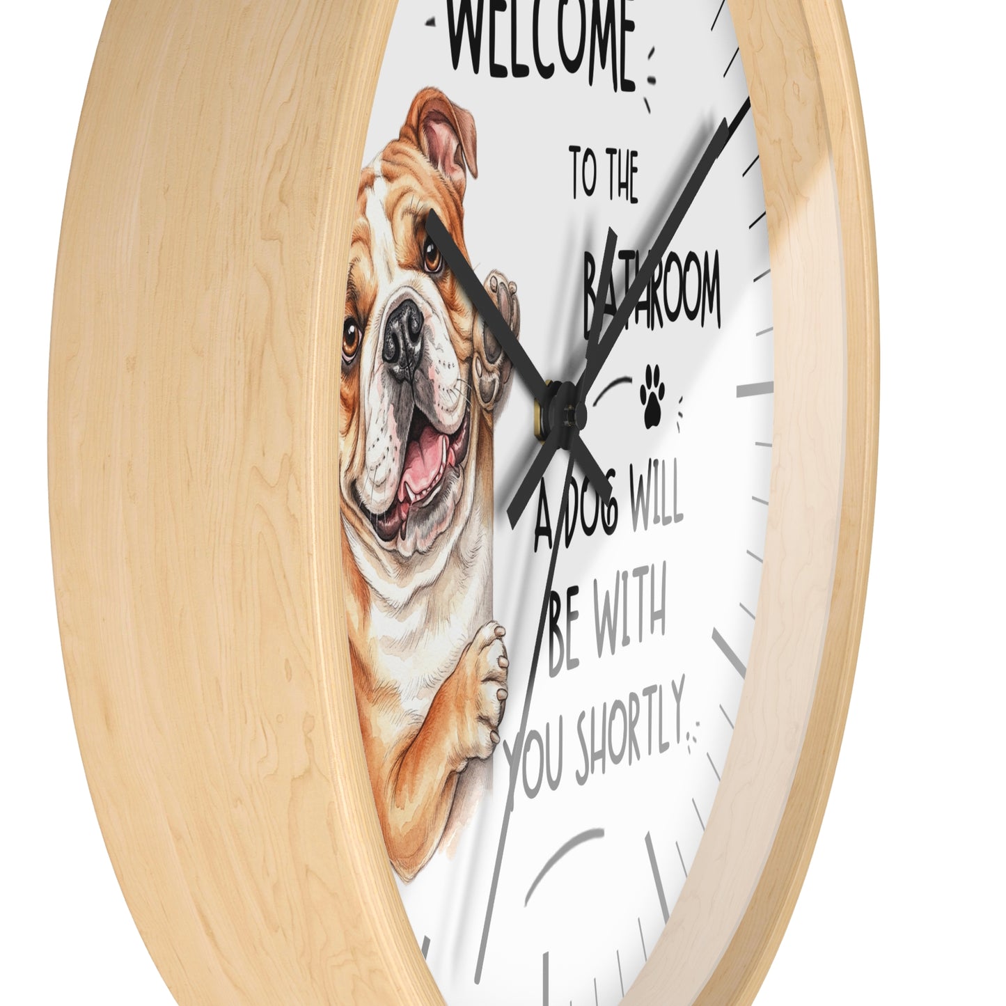 A round wall clock with a light natural wood frame and a white face, featuring a painted bulldog illustration and the text 'WELCOME TO THE BATHROOM A DOG WILL BE WITH YOU SHORTLY'.